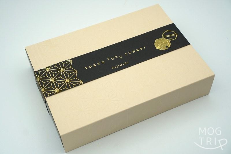 「富士見堂 グランスタ東京店」の東京鈴せんべいの箱が、テーブルに置かれている