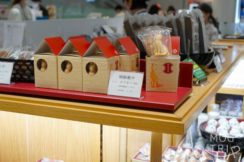 【東京・渋谷スクランブルスクエア限定品】銀座甘楽の「御餅最中（ハチ公最中）3個入」の箱が木のカウンターの上に並べられている