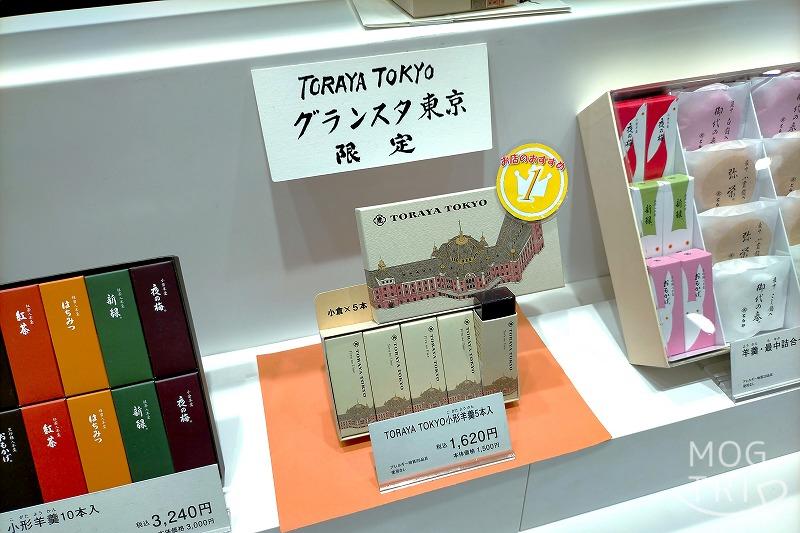 東京駅にある「とらやグランスタ東京店」と「TORAYA TOKYO」の限定品、小形羊羹 夜の梅® 5個入の箱が白いカウンターに置かれている