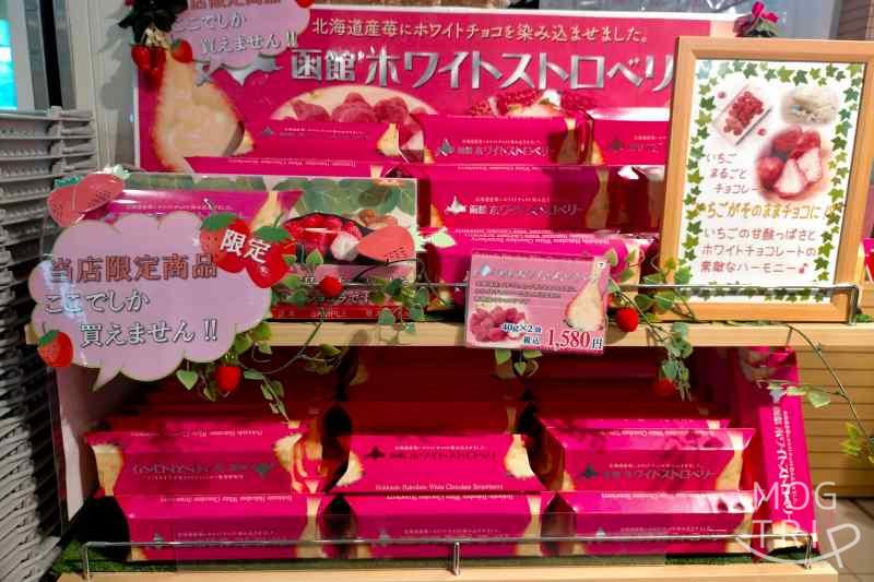 函館駅「北海道四季彩館JR函館店」限定品 函館ホワイトストロベリーの箱が、木の棚にたくさん並べられている