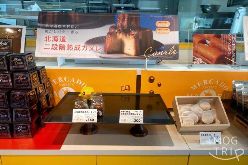 札幌場外市場にあるメルカードスイーツまるの店頭に、二段階熟成カヌレが並べられている