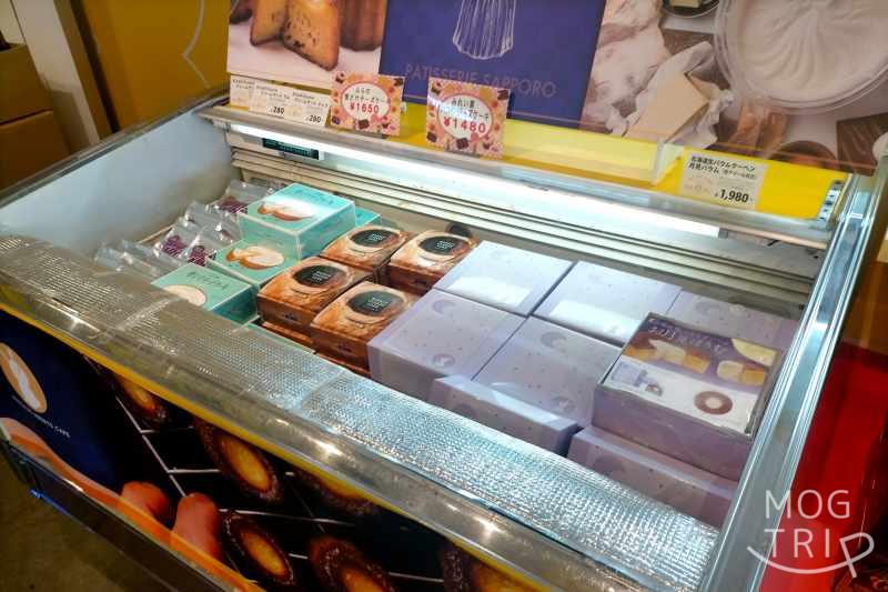 札幌場外市場にあるメルカードスイーツまるの冷蔵ケースに生バウムクーヘンやチーズケーキなどがたくさん入っている