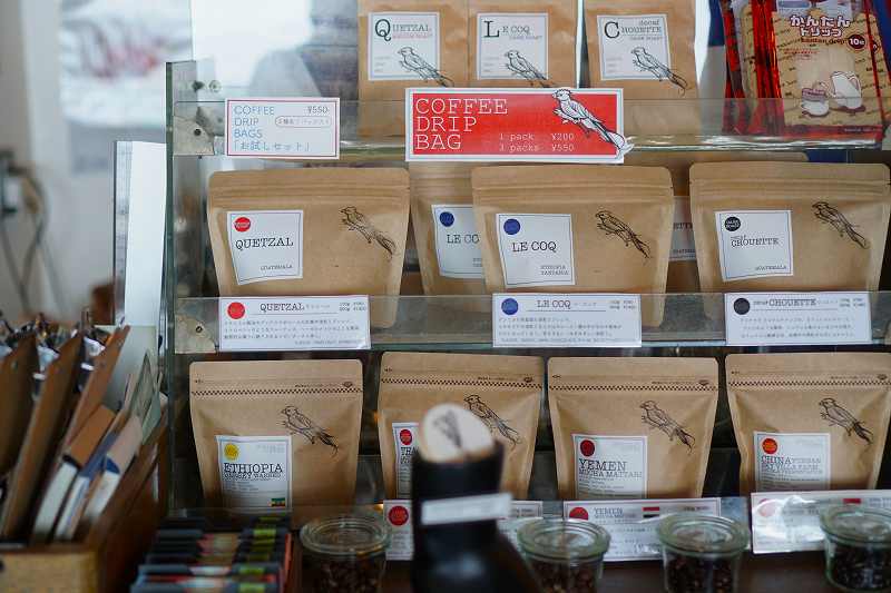 カフェトコシエのコーヒー豆とドリップバックがプラスチックの棚に並べられている