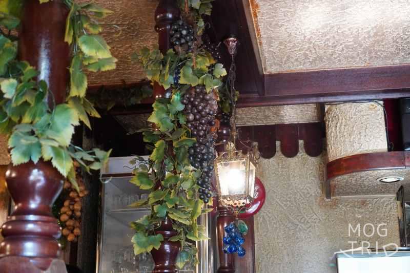 「ポテト料理専門店 穀物祭」の店内に葡萄の飾りがぶら下がっている