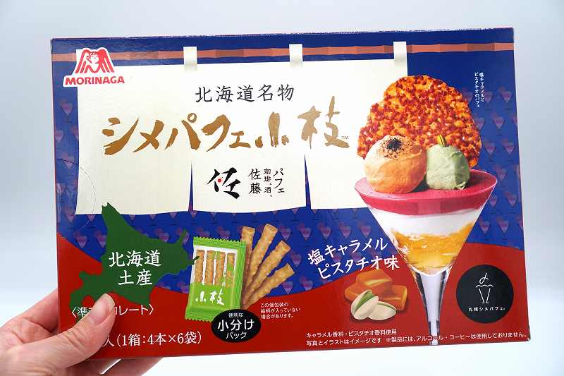 森永製菓「北海道名物 シメパフェ小枝（塩キャラメルピスタチオ味）」を手に持っている様子