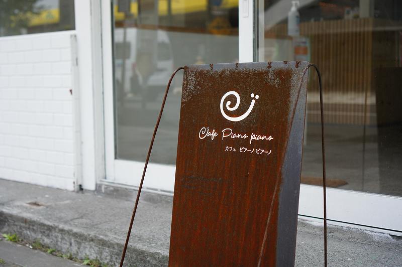 Cafe Piano Piano（カフェピアーノピアーノ）の店名看板が店前に置かれている