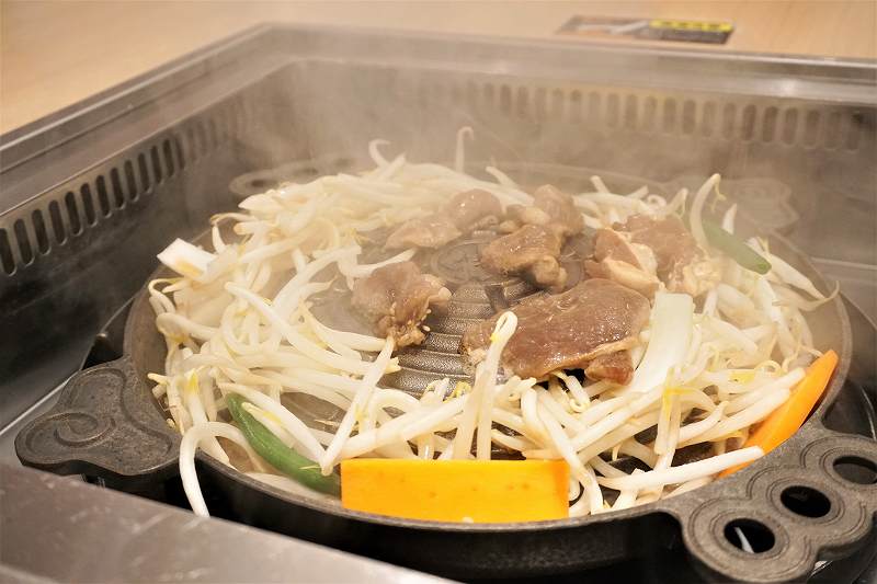 松尾ジンギスカン専用鍋で、ジンギスカンが焼かれている様子