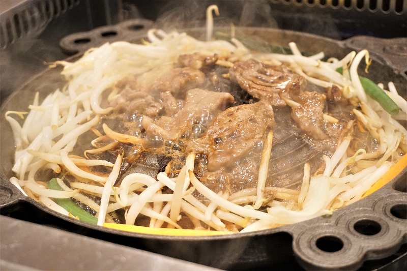 松尾ジンギスカン専用鍋で、ジンギスカンが焼かれている様子