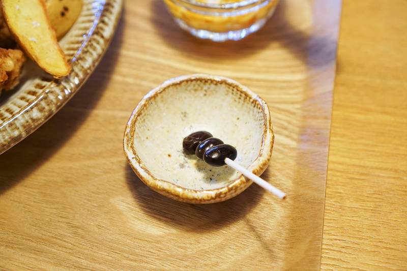 黒豆を楊枝でさしたものがテーブルに置かれている