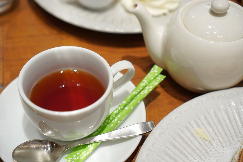 ティーポットとカップに入った紅茶がテーブルに置かれている