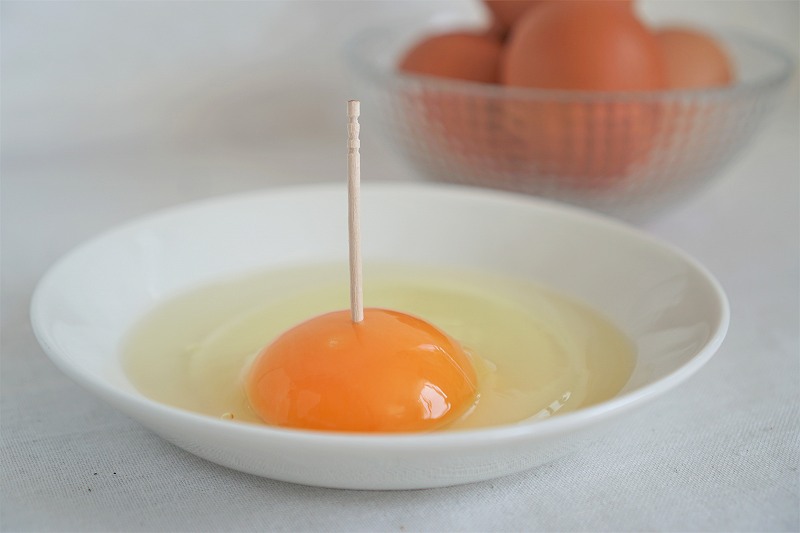 爪楊枝を立てた生卵がテーブルに置かれている