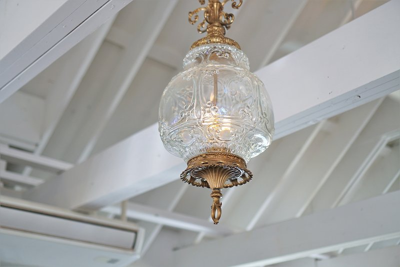 アンティーク風の美しいガラスの照明が天井から吊るされている