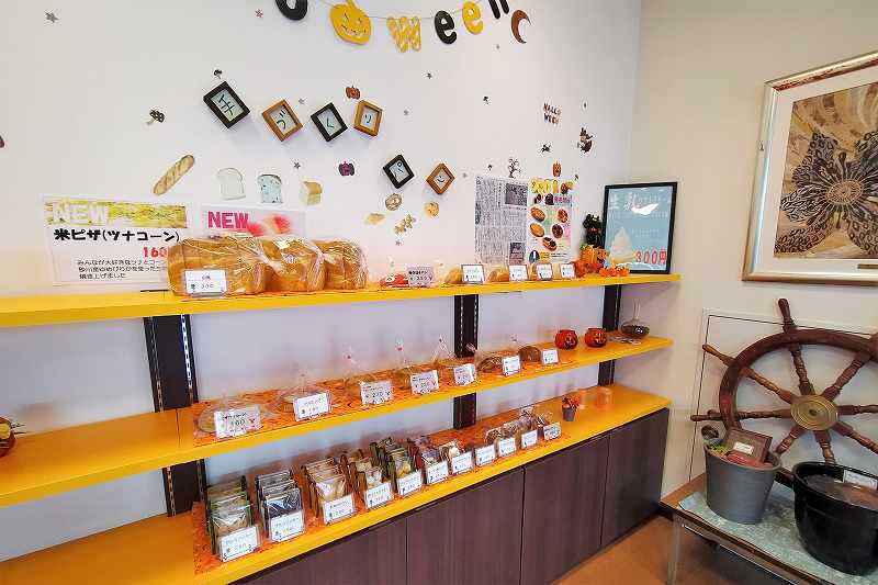 黄色い棚にいろいろなパンが並べられている、カフェくるみるの内観