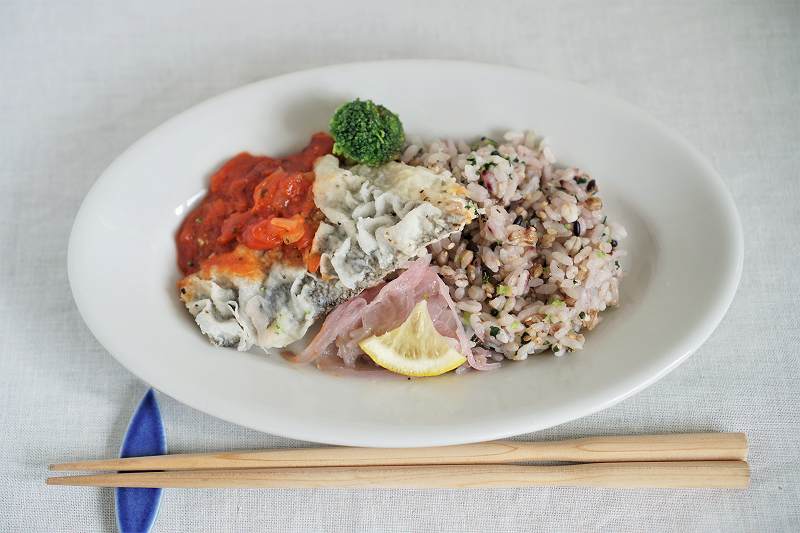 白身魚と野菜のマリナラソース煮弁当がテーブルに盛りつけられ、テーブルに置かれている