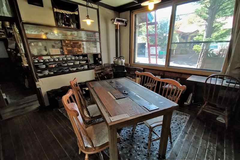 木のテーブルと椅子がならぶ「玄米自然食 ゆるり庵」の内観