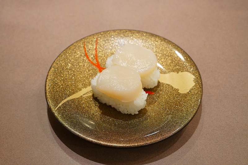 回転寿司とっぴ～ 旭川宮前店の「北海道産生ほたて（税込462円）」がテーブルに置かれている
