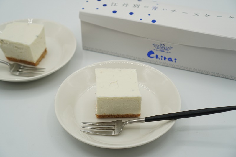 小さくカットされた江丹別の青いチーズケーキがテーブルに置かれている