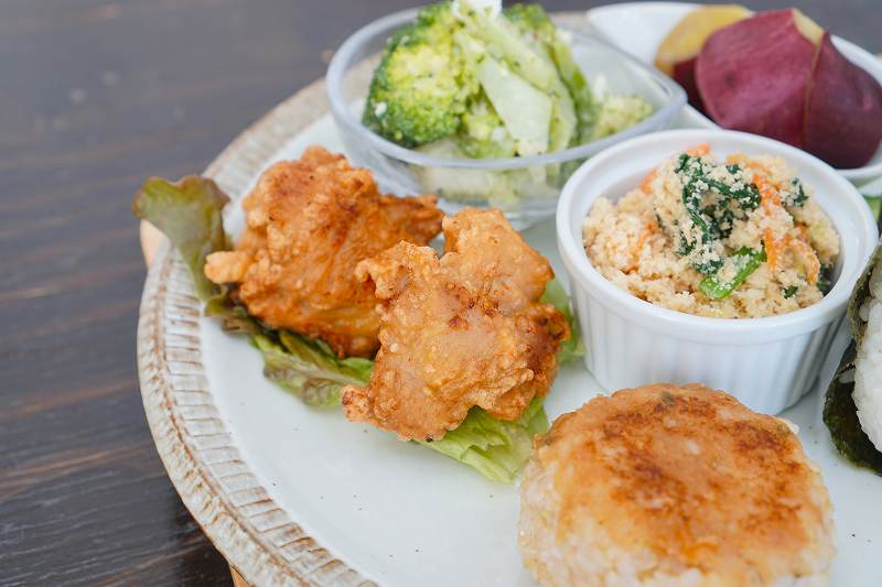 鶏肉の唐揚げや副菜が盛られたプレートがテーブルに置かれている