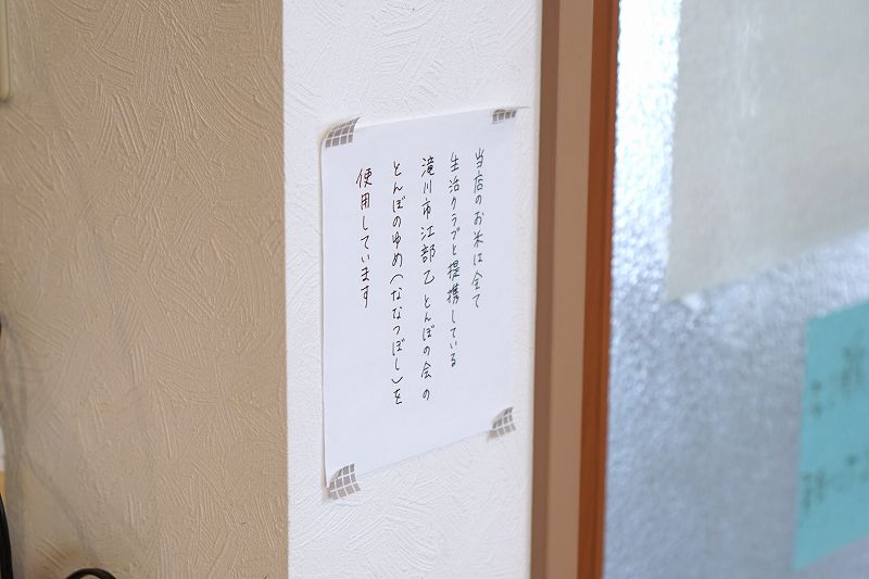 「おむすびcafe粒」で使用するお米の説明が壁に貼られている