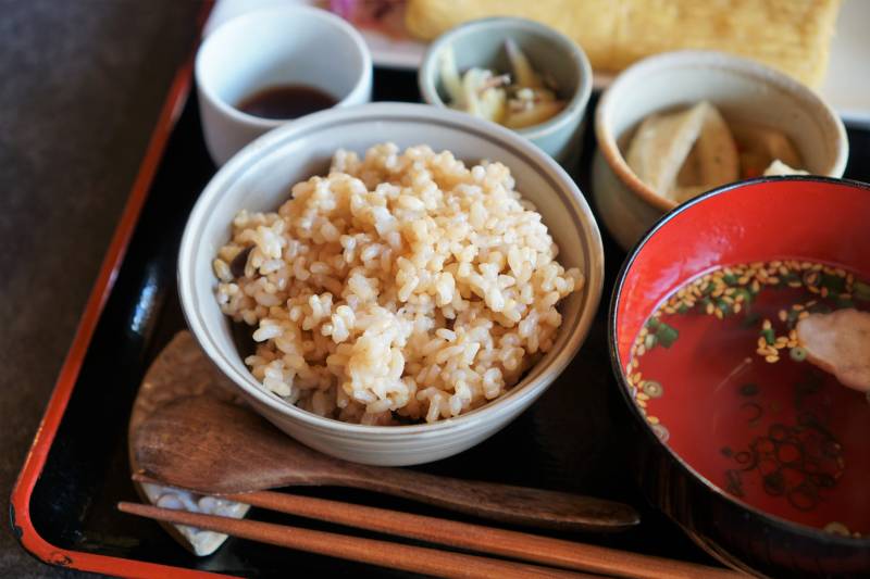 玄米ご飯と小鉢、お吸い物などがテーブルに置かれている