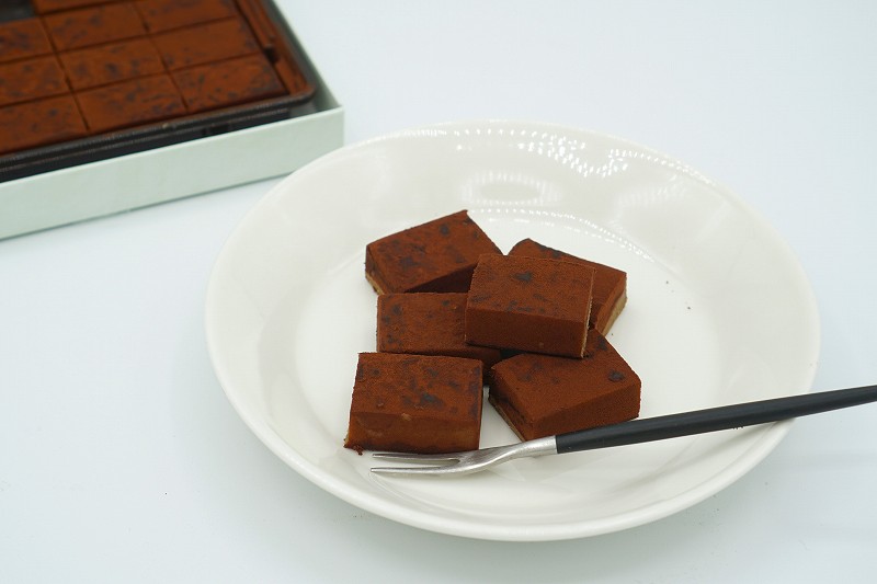 ロイズ石垣島の「生チョコレート 黒糖（税込800円）」が皿にのせられ、テーブルに置かれている