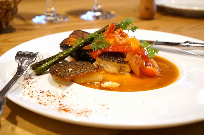 「ヒラメのソテー」魚介のソースとピペラードがテーブルに置かれている