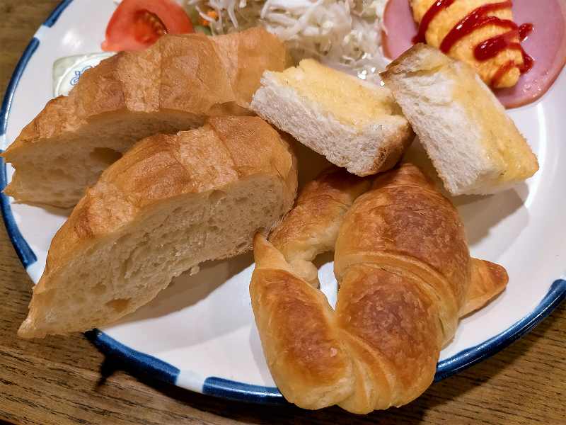 クロワッサン・バタートースト・フランスパンなどが皿にのせられ、テーブルに置かれている