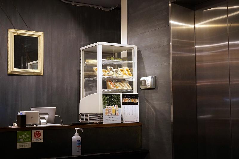 カラフルなフルーツサンドが入っている冷蔵庫がカウンターの上に置かれている