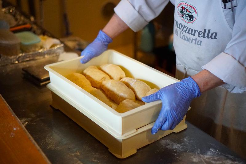 小沢シェフが完成したパン生地が入ったケースを手に持っている様子
