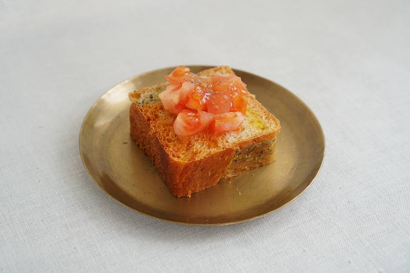 トマトをトッピングしたトマトバジルカプレーゼ食パンがテーブルに置かれている