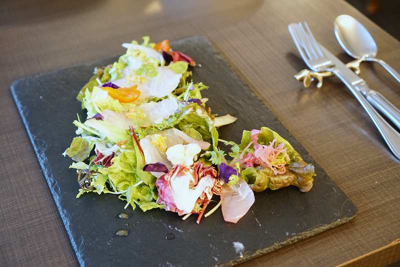 前菜の天然真鯛のカルパッチョ、サラダがテーブルに置かれている