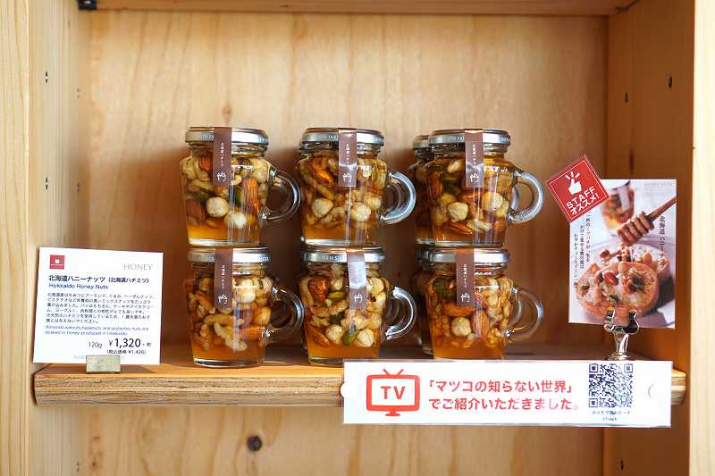テレビ番組「マツコの知らない世界」で紹介された「北海道ハニーナッツ」が木の棚に並べられている