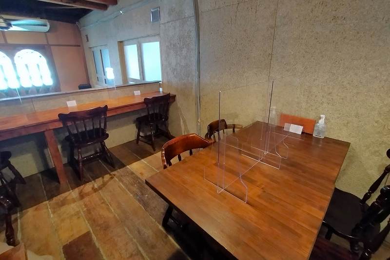 木のテーブルとイスが置かれているブラウンブックスカフェの内観
