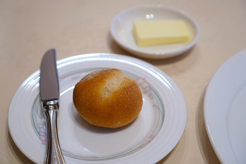 丸いパンとバターがテーブルに置かれている