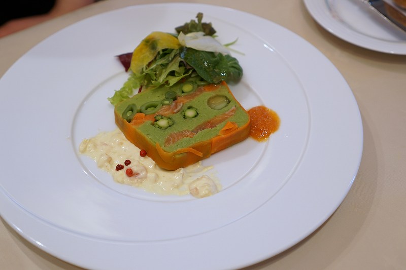 【前菜】春野菜と桜鱒のマリネのテリーヌ サフラン風味のソース・ムーステリーヌがテーブルに置かれている
