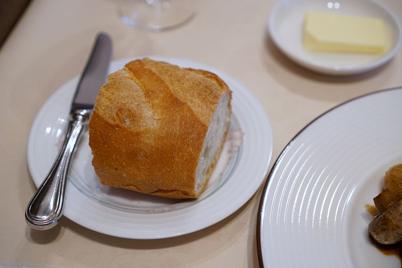 フランスパンとバターがテーブルに置かれている