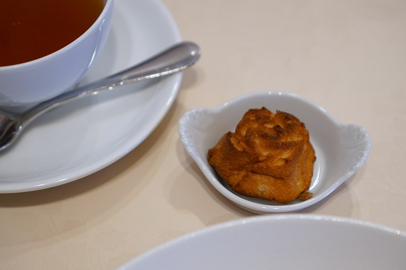 紅茶とバラの形の小菓子がテーブルに置かれている