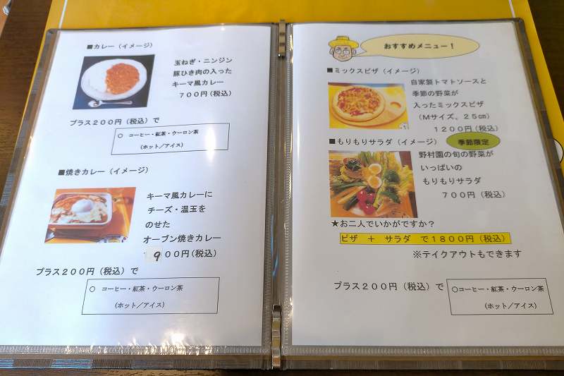 「北広島野村園 NOMUキッチン」のカレーやピザメニューがテーブルに置かれている