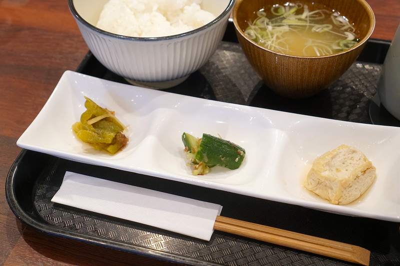 豆腐、生姜が香るきゅうりの漬物、ピーマンのおかか和えがテーブルに置かれている