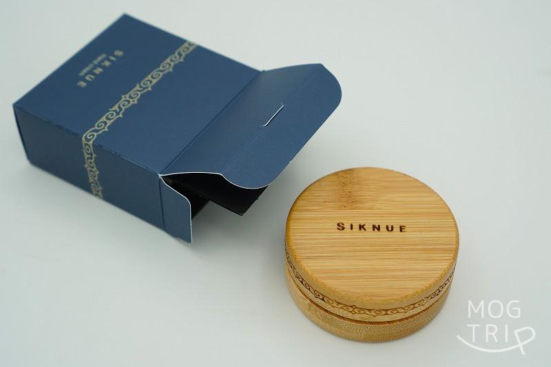 SIKNUE（シクヌ）のサーモンコラーゲン ハンドクリームと箱がテーブルに置かれている