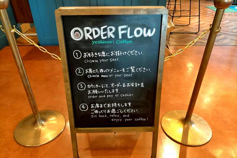 ヨシノリコーヒー旭川駅前店のオーダーの仕方の説明看板が床に置かれている