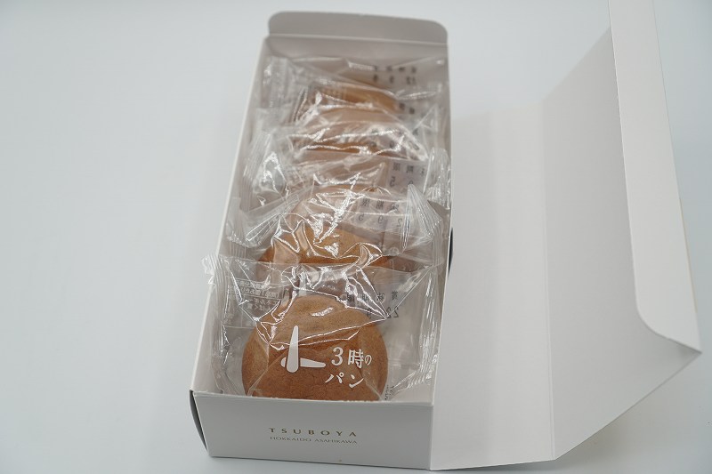 透明な個包装のおまんじゅう「3時のパン」がテーブルに置かれている