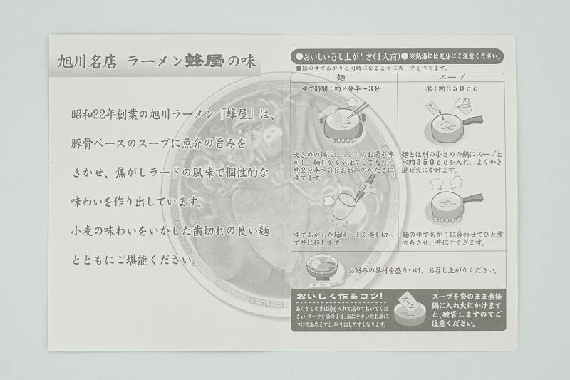 旭川ラーメン 蜂屋のおみやげ生ラーメンの作り方説明書がテーブルに置かれている