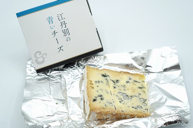 「江丹別の青いチーズ 100g（税込800円）」がテーブルに置かれている