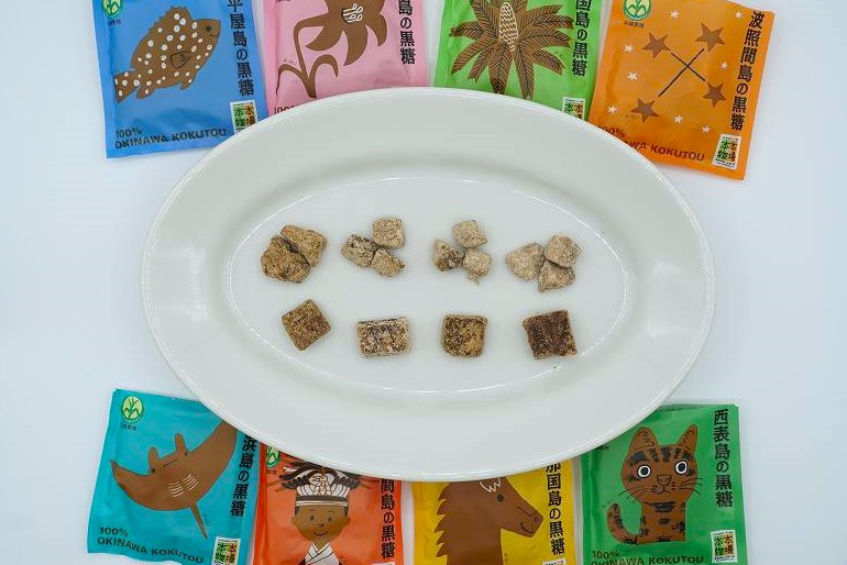 沖縄の8種類の黒糖が皿にのせられ、テーブルに置かれている