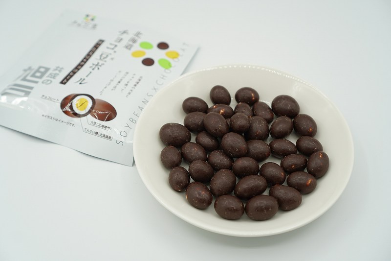チョコレートで旭豆をコーティングした「チョコ’豆ボール」がテーブルに置かれている