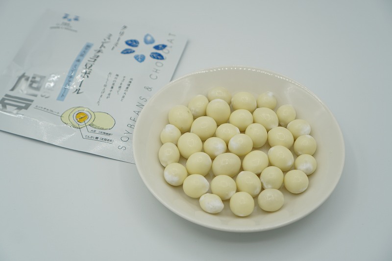 ミント風味のホワイトチョコレートで旭豆をコーティングした「ミントチョコ’豆ボール」がテーブルに置かれている