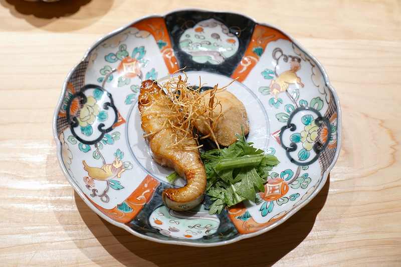 里芋や春菊、魚が盛られたお皿がテーブルに置かれている