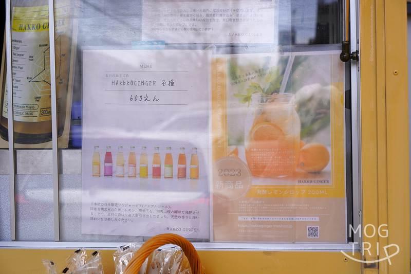 ハッコウキッチン桑園の「発酵レモンシロップ」と「HAKKO GINGER」のメニュー表がキッチンカーに貼られている