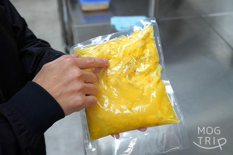 ハッコウキッチン桑園の代表・前田 伸一さんが、袋に入ったレモンの絞りかすを手に持っている様子